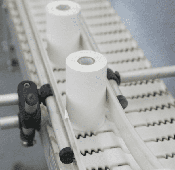 Two rolls of handheld printer labels moving across a conveyor belt