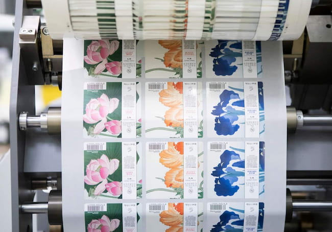 a roll of labels going into a Bobst Digital Master Printing Press