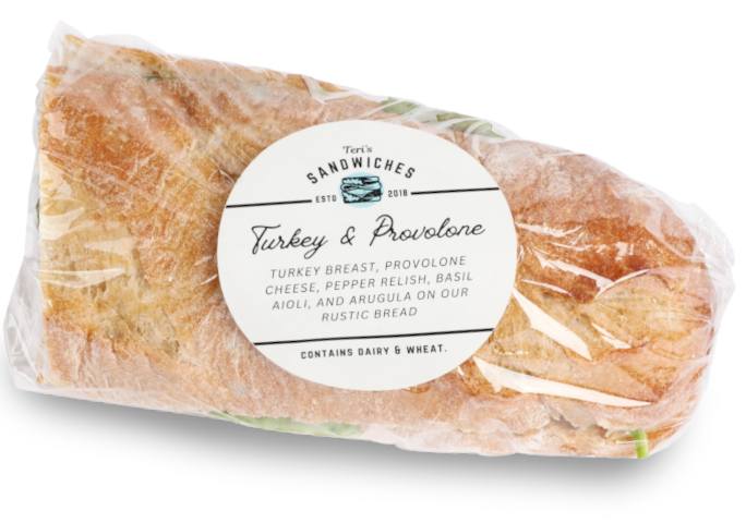a labeled, saran wrapped turkey sandwich
