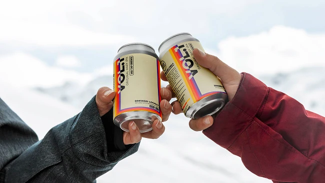 2 jacketed arms clinking cans of IPA together in a winter environment