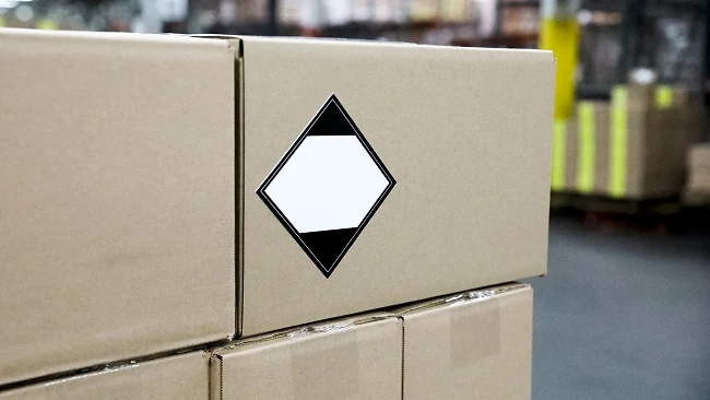 a stack of cardboard boxes, the top rightmost box has a blank quantity label