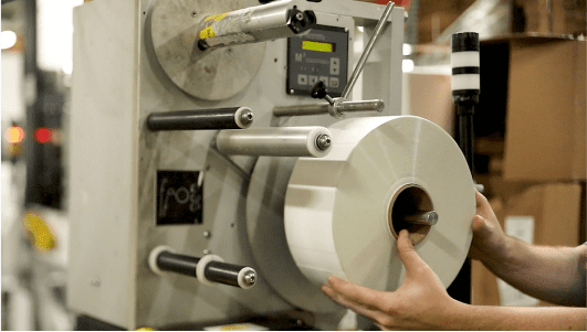 A roll of labels being placed onto a print and apply machine