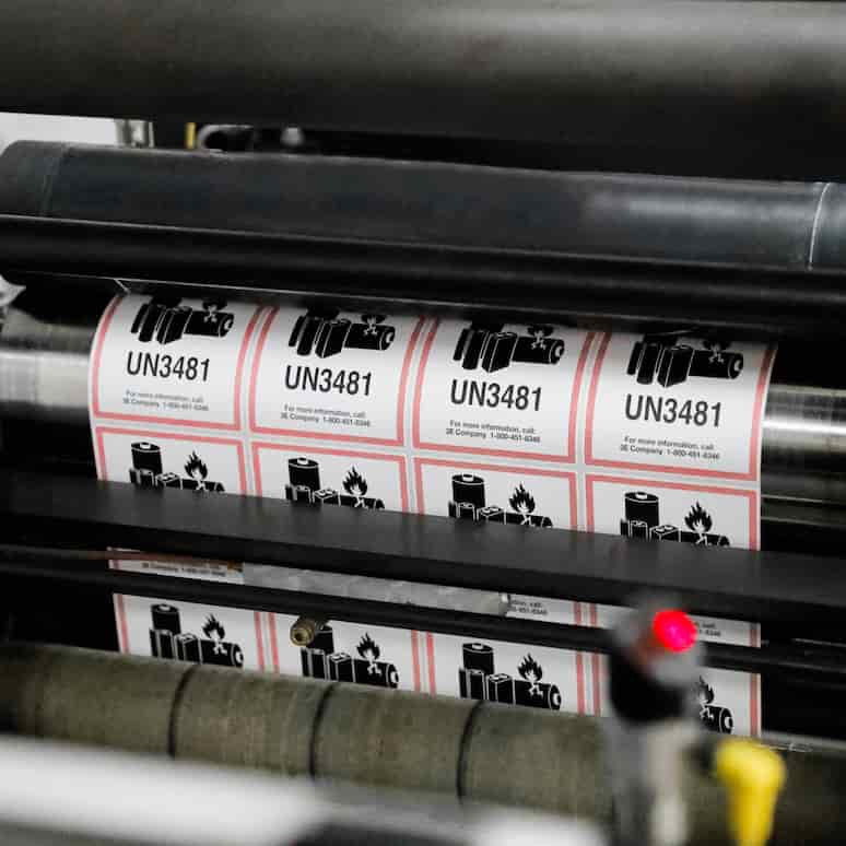 a sheet of UN 3481 labels bing printed in a machine