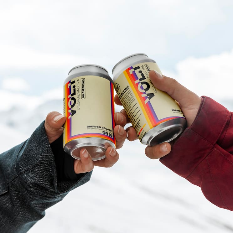 two arms tapping cans of IPA together like during a 