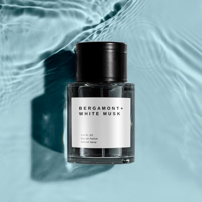 a bottle of cologne sitting on a surface covered in shallow water