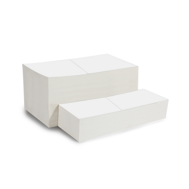 a stack of blank fanfold labels sitting in front of a larger stack