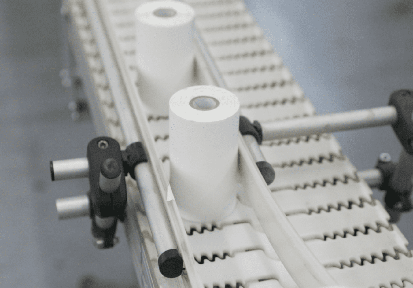 Two rolls of handheld printer labels moving across a conveyor belt
