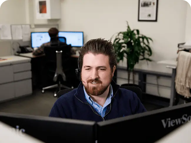 a team member sitting at a computer in an office, providing customer service
