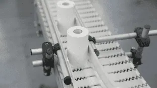 Two rolls of handheld printer labels moving across a conveyor belt.