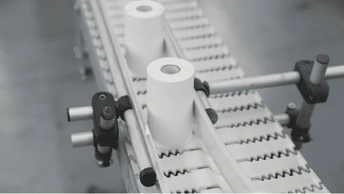 Two rolls of handheld printer labels moving across a conveyor belt.