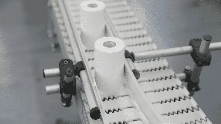 Two rolls of handheld printer labels moving across a conveyor belt.
