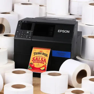 An Epson ColorWorks C6000 printer surrounded by blank label rolls