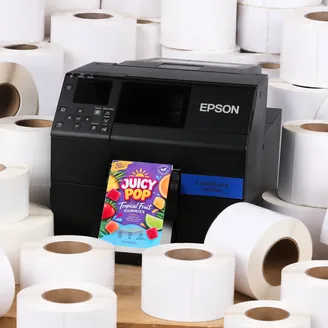 An Epson ColorWorks C6000 printer surrounded by blank label rolls