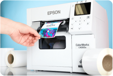 A high quality printed inkjet label being removed from an Epson ColorWorks inkjet printer. There are rolls of blank inkjet labels next to the printer.